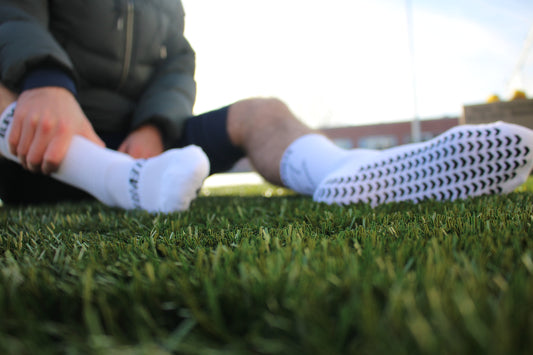 White Elevate grip socks. Designed for footballers, by footballers.