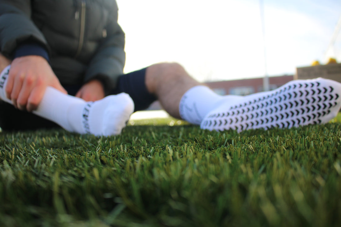 White Elevate grip socks. Designed for footballers, by footballers.